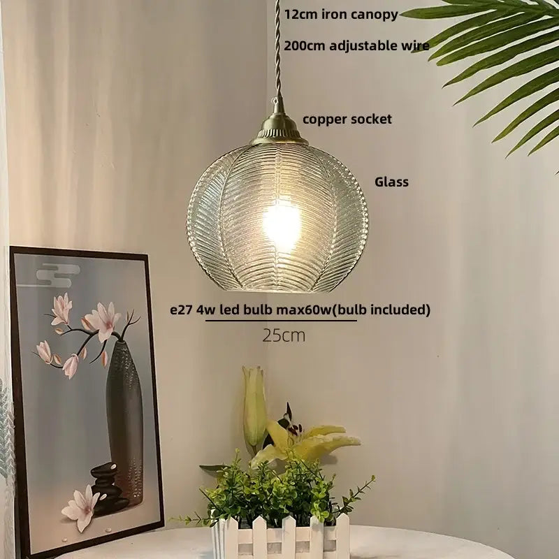 A modern blue glass led pendant light with a ribbed spherical design and brass fittings for kitchen decorbites decor