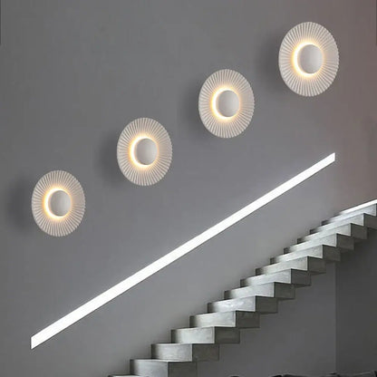 Modern ribbed circular white and gold led wall lamps with a ribbed design and warm glowing light for bedroom lighting