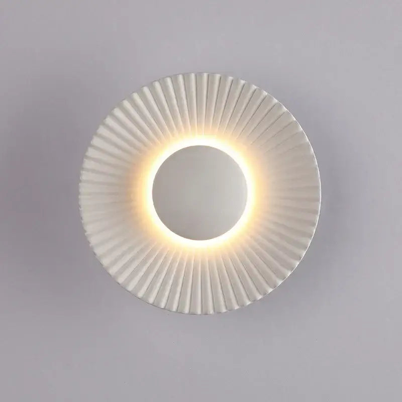 Modern ribbed circular white ceramic led wall lamp with gold sunburst design and warm led ring light for bedroom lighting