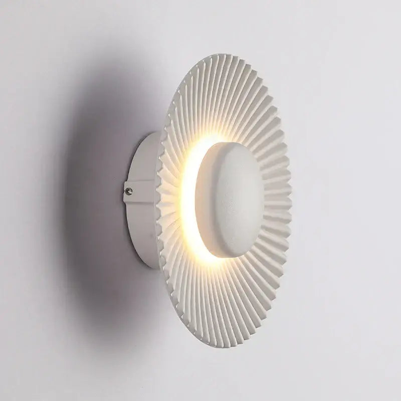 Modern ribbed circular white led wall lamp with radial ridges and illuminated center for bedroom lighting