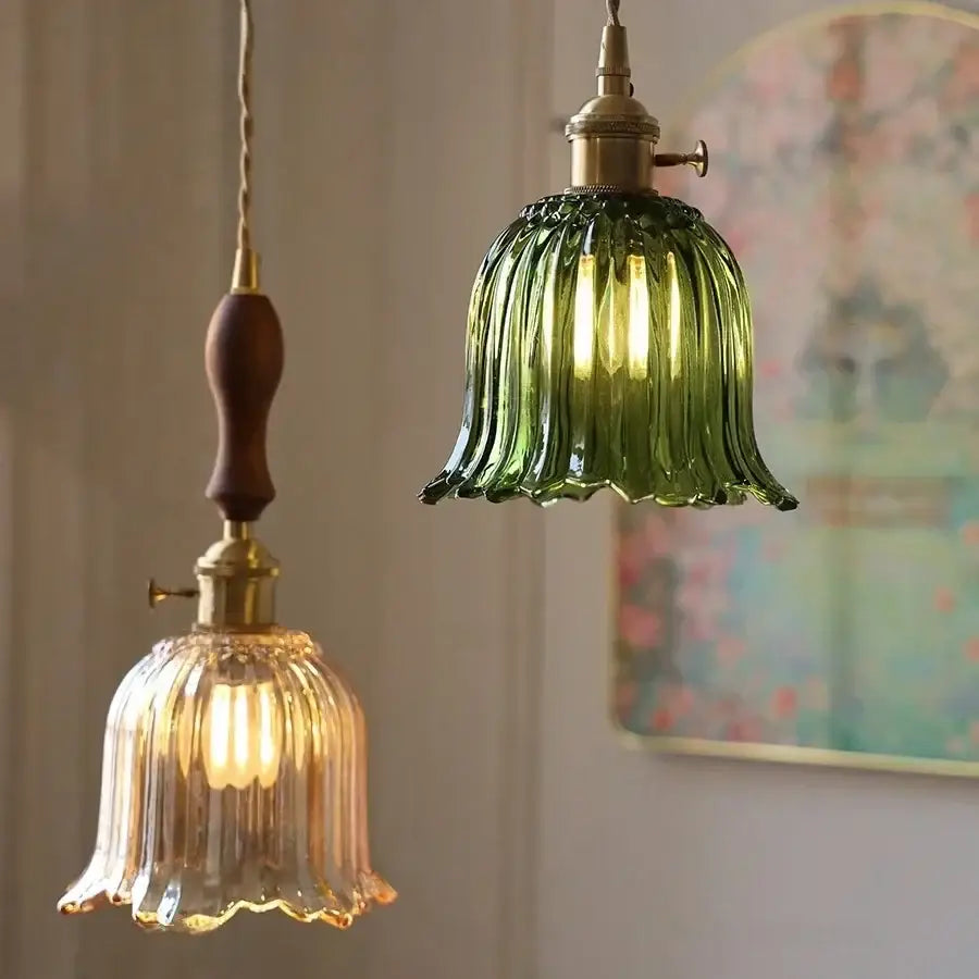 Two vintage-style pendant lights featuring a green ribbed glass and brass decorbites clear glass led fixture with wooden handle