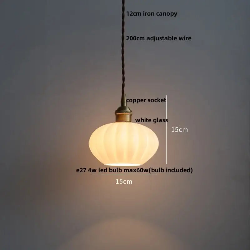 A warm softly glowing copper white glass pendant lamp with ribbed shade and antique brass socket for living room decorbites decor