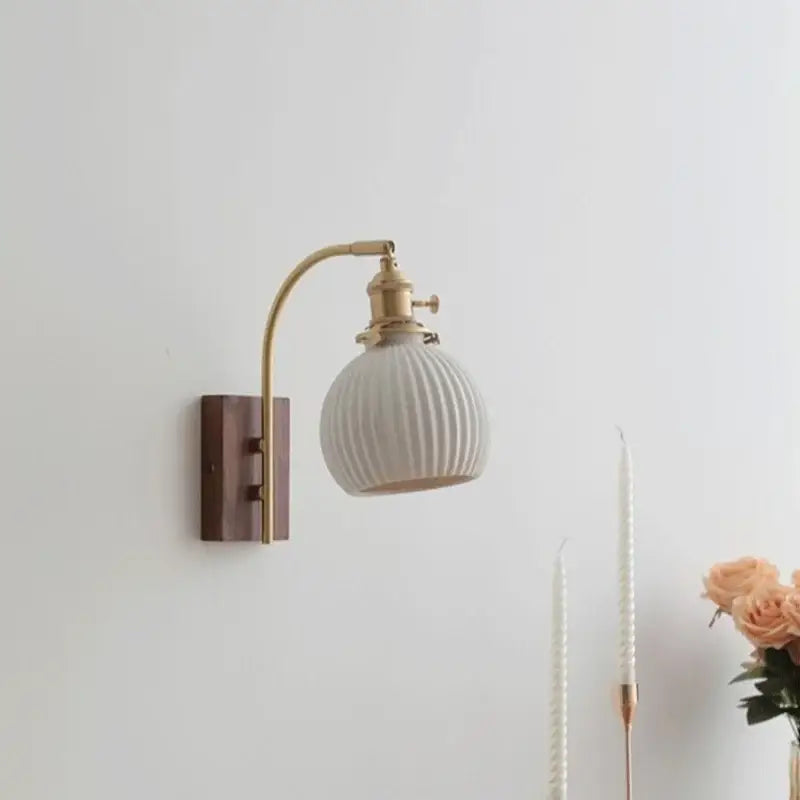 A vintage-style wall light with cream ribbed glass shade brass arm and dark walnut backplate for bedroom decorbites ceramic walnut led