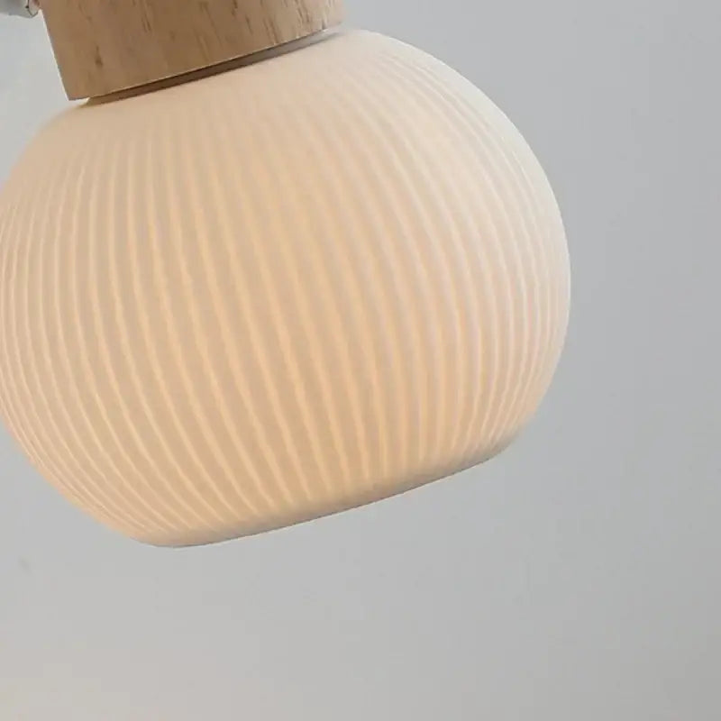 Cream-colored ribbed glass ceramic led wall light with natural wood top for modern bedroom decorbites ceramic led lighting
