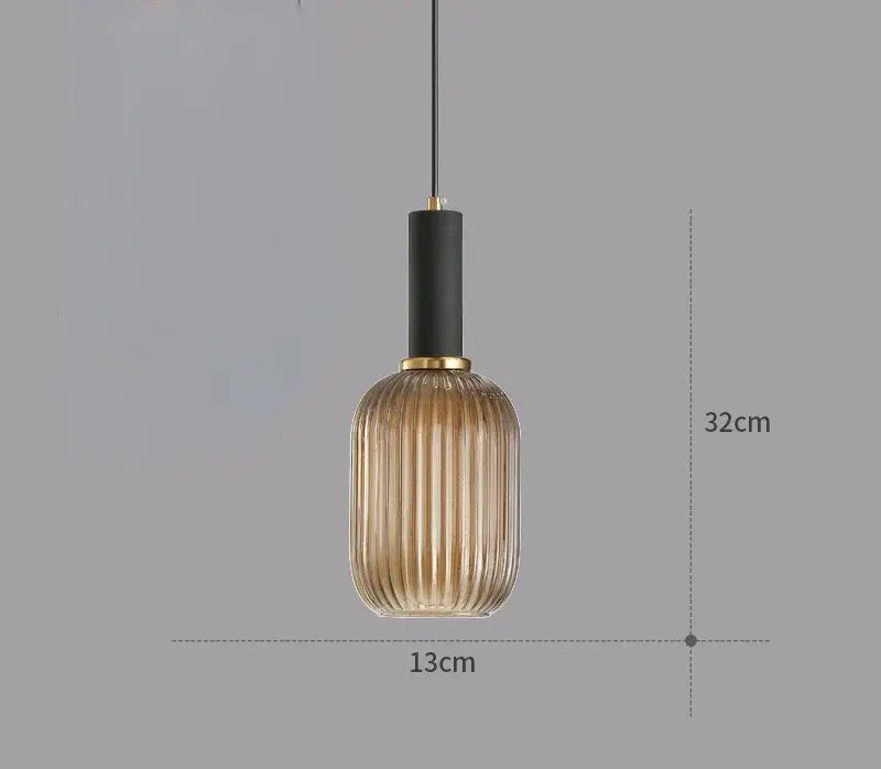 A modern pendant light chandelier with a ribbed amber glass shade and gold-toned accents for dining rooms
