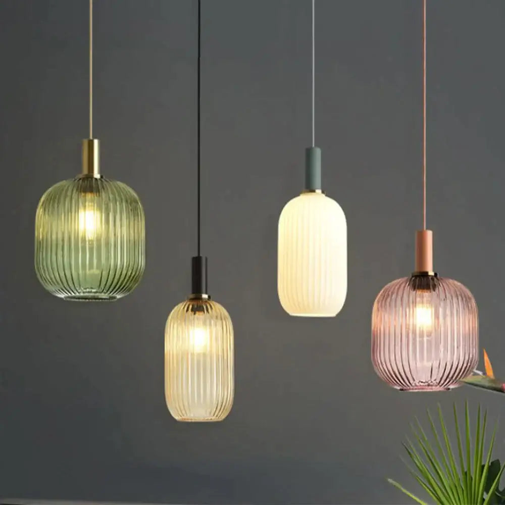 Four modern light chandeliers with ribbed glass colorful led shades in green amber cream and pink hues for dining rooms