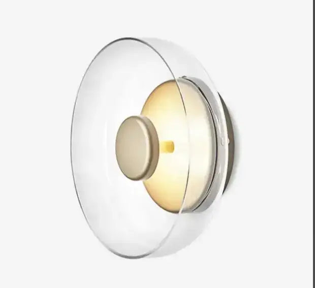 Modern minimalist wall lamp with clear glass dome, frosted beige shade, and brushed copper led wall accents for bedroom decor