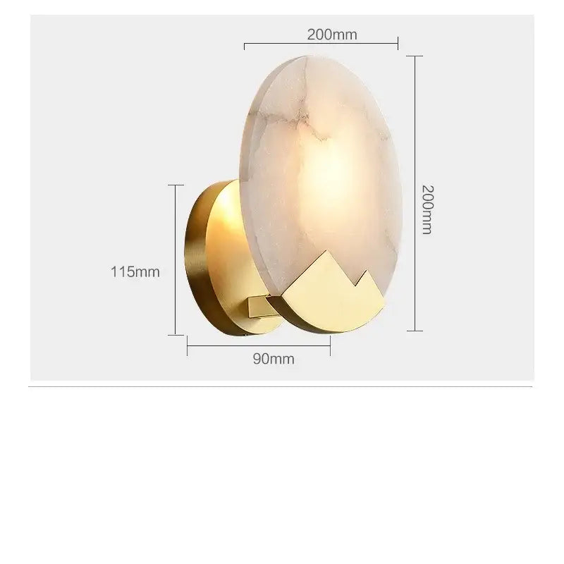 Modern wall lamp with a warm oval marble shade and polished gold-toned copper led wall base with geometric cutouts