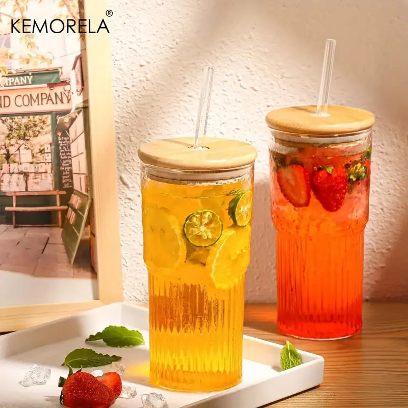 Modern ribbed glass cup with bamboo lid and straw filled with colorful fruit-infused drinks in clear ribbed glass