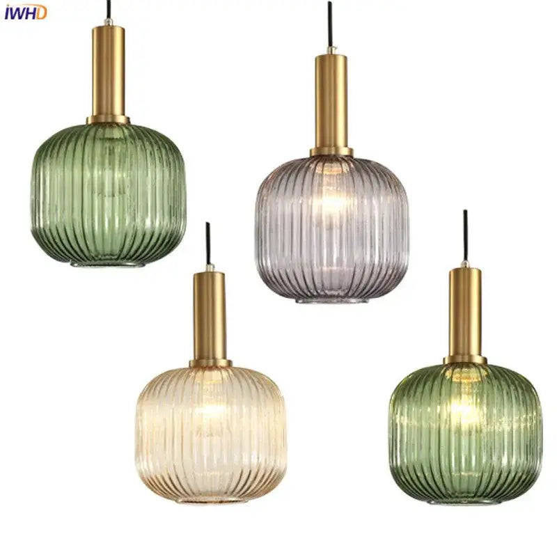 Four modern glass pendant lights with ribbed green, gray, and beige shades and brass stems for dining room use