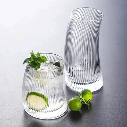 Modern ribbed sail-shaped glass cups featuring clear vertical ribbed texture with one filled with ice and mint garnish