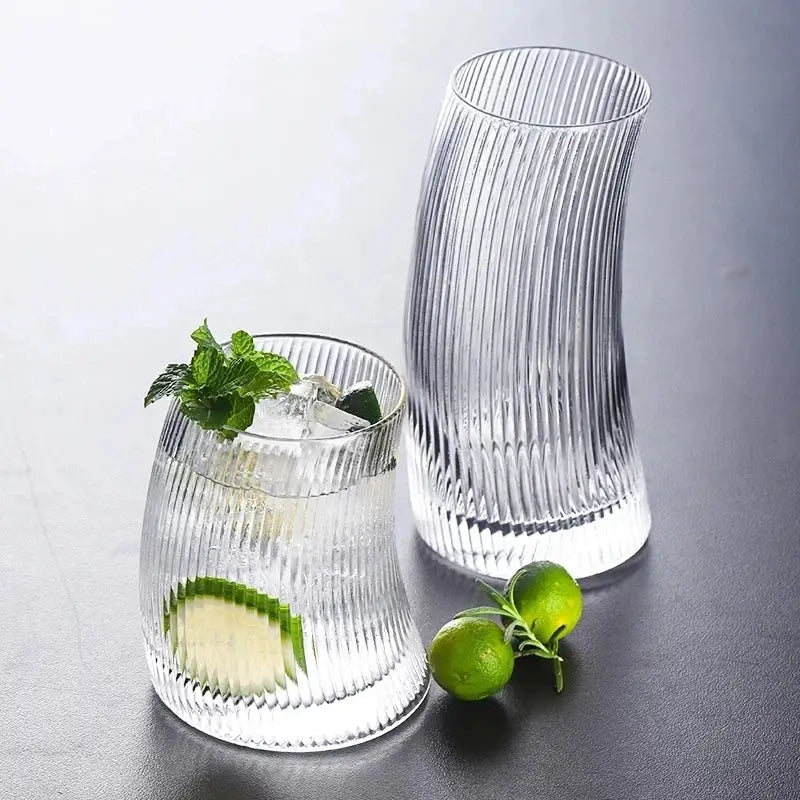 Modern ribbed sail-shaped glass cups featuring clear vertical ribbed texture with one filled with ice and mint garnish