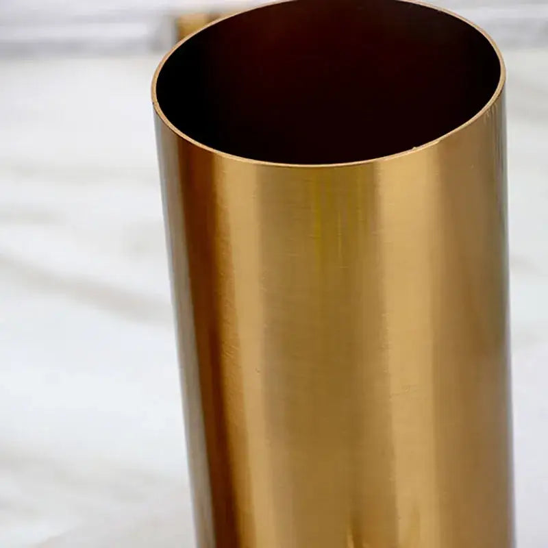 A sleek cylindrical gold plated vase with ridged design and polished brass finish for modern living room decorbites decor