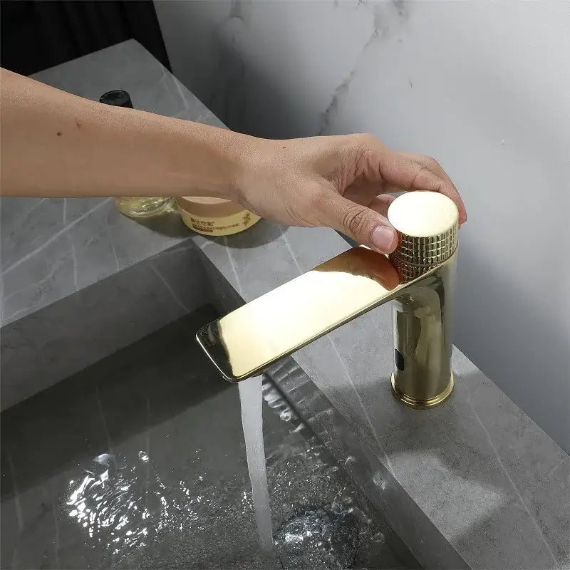 Modern ridged gold sensor mixer faucet with a sleek rectangular spout and textured cylindrical handle for bathroom sink