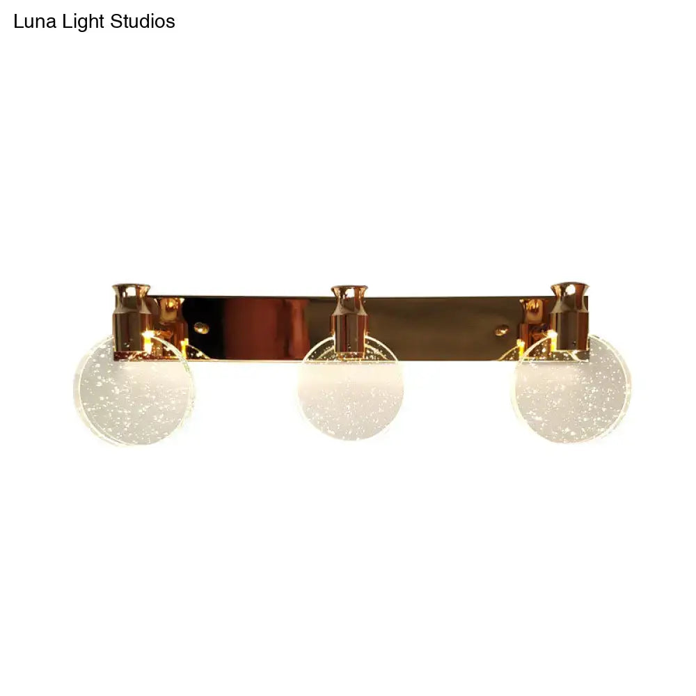Modern rose gold 3-light wall vanity light with gold-toned fixture and frosted glass globe shades for bathroom use