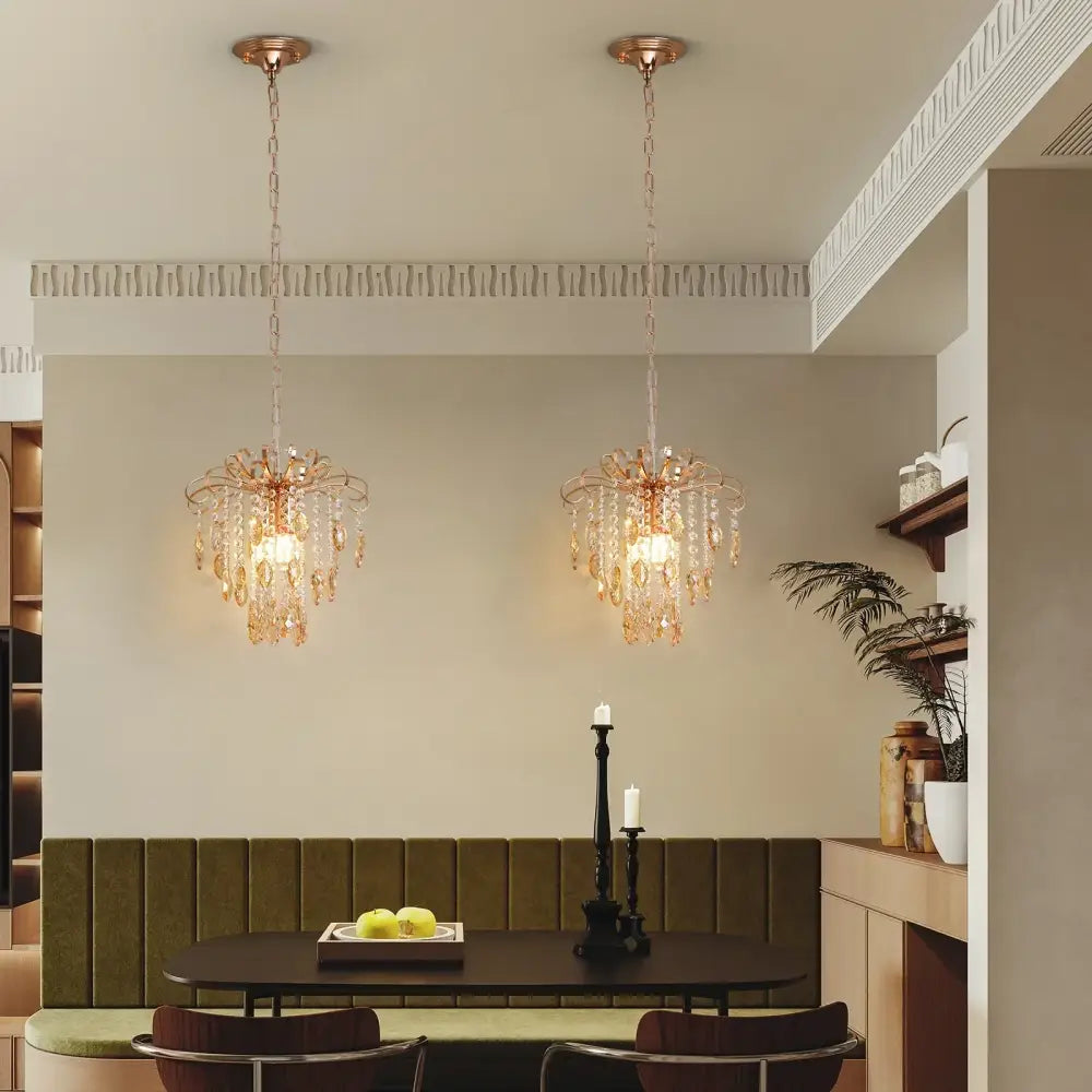 Two rose gold crystal led pendant lights with amber crystal droplets hang as modern decorbites pendant light fixtures