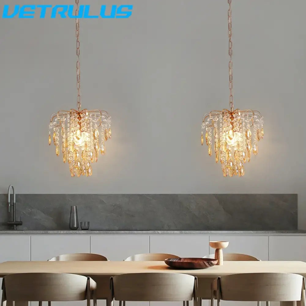 Two elegant copper-toned decorbites crystal led pendant lights with cascading amber crystals hang above dining table