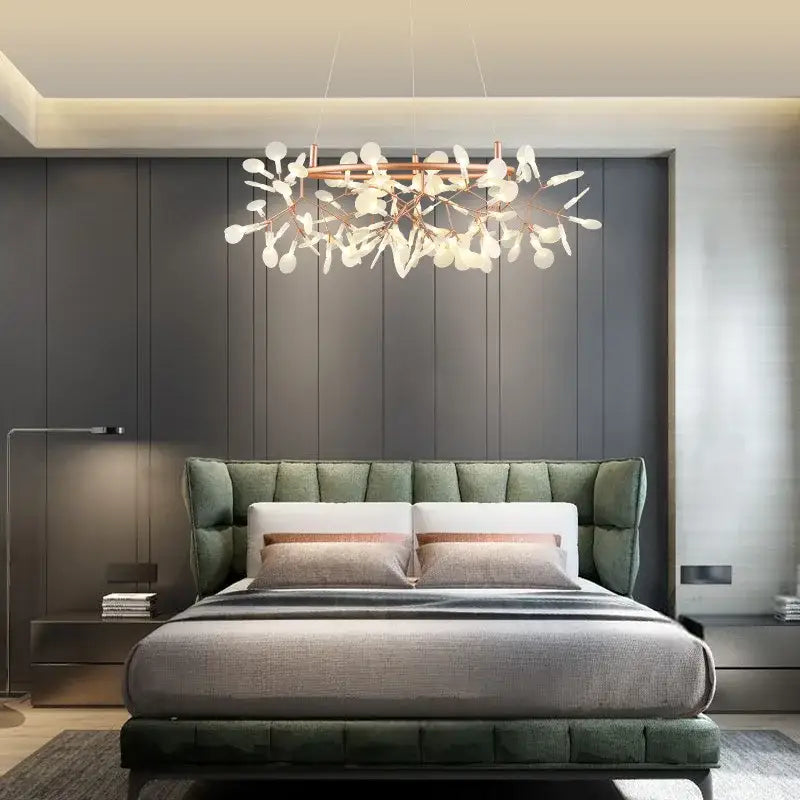 Modern rose gold pendant light with copper-toned frame and white leaf-shaped glass light sources above bed