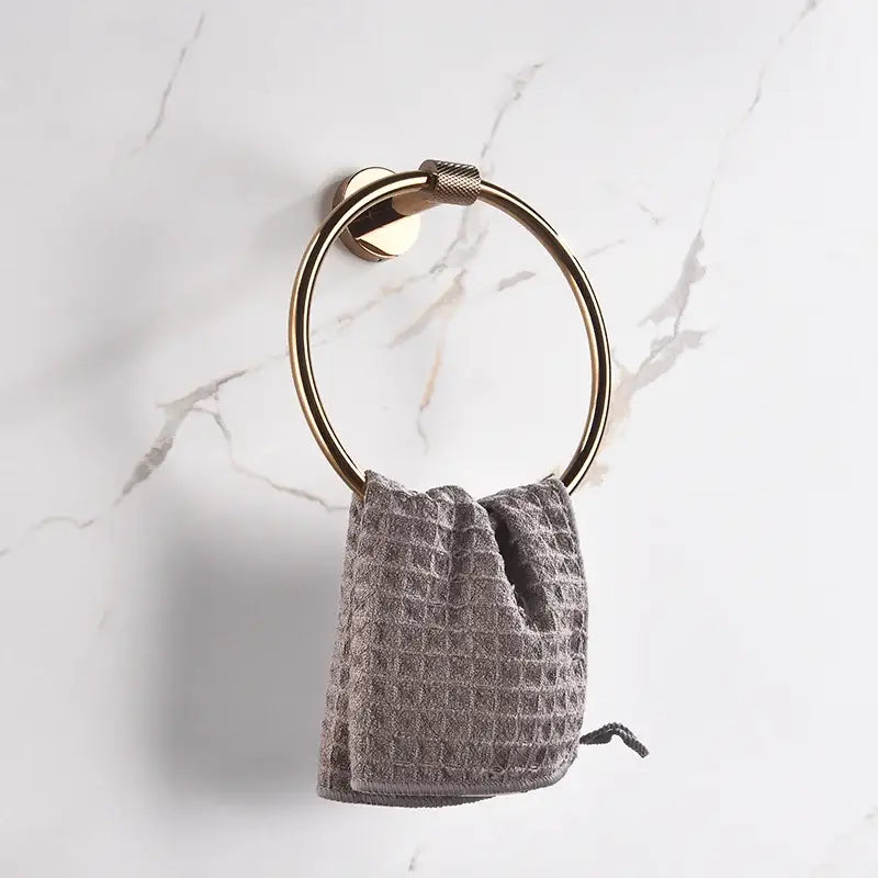 Modern rose gold stainless steel circular towel ring with textured grip holding gray waffle weave towel decorbites bathroom accessories