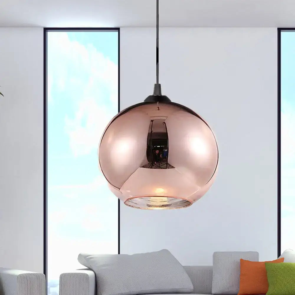 Modern rose gold copper sphere pendant light featuring a sleek reflective glass globe and black metal hardware for kitchen bar