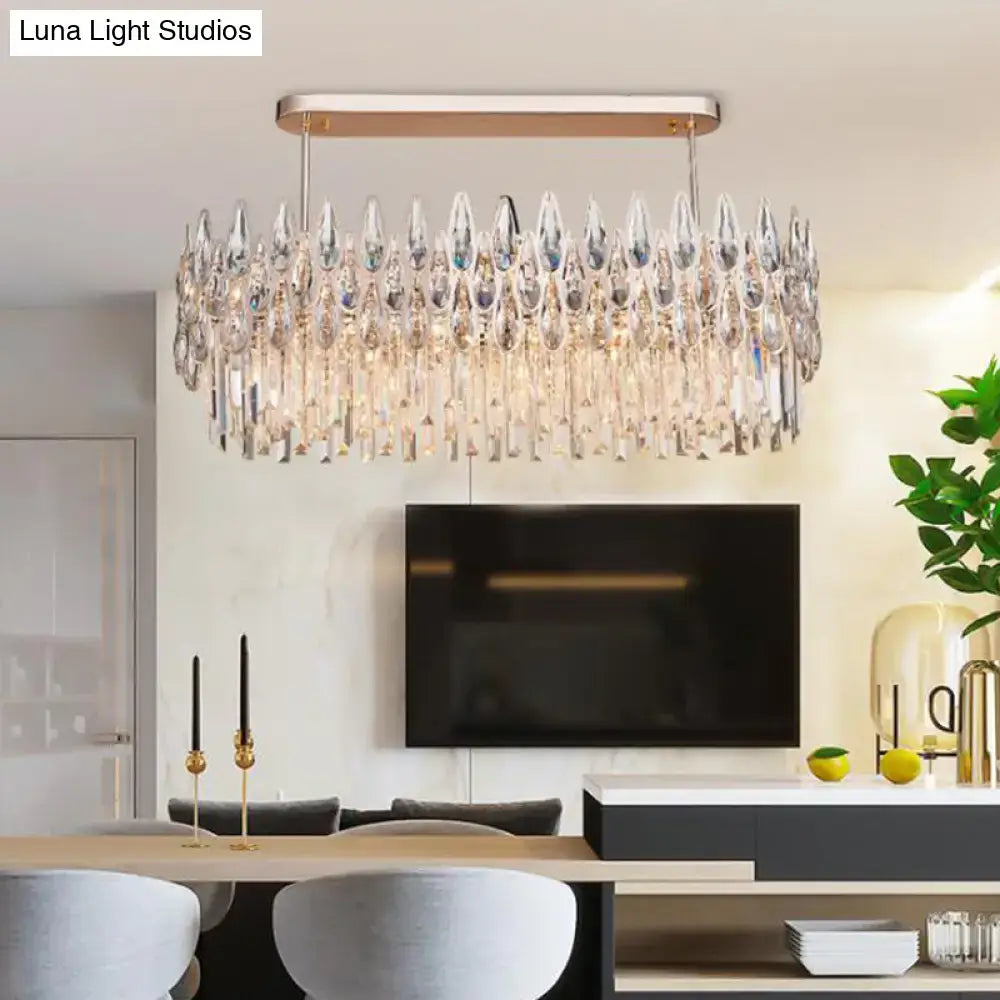 A modern rose gold crystal island lamp featuring a rectangular frame and oval clear cascading crystal teardrop pendants