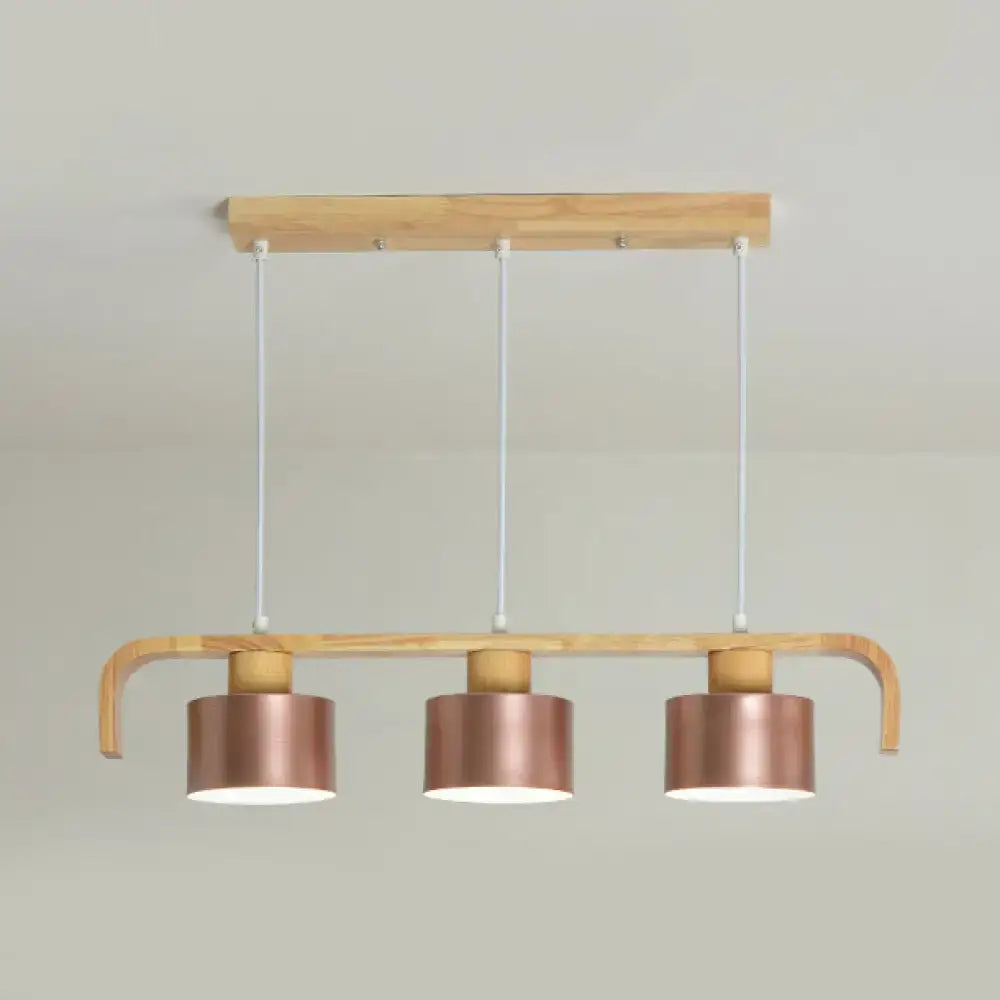 Modern rose gold drum island chandelier with copper-finished pendant lights on light wood frame for dining table