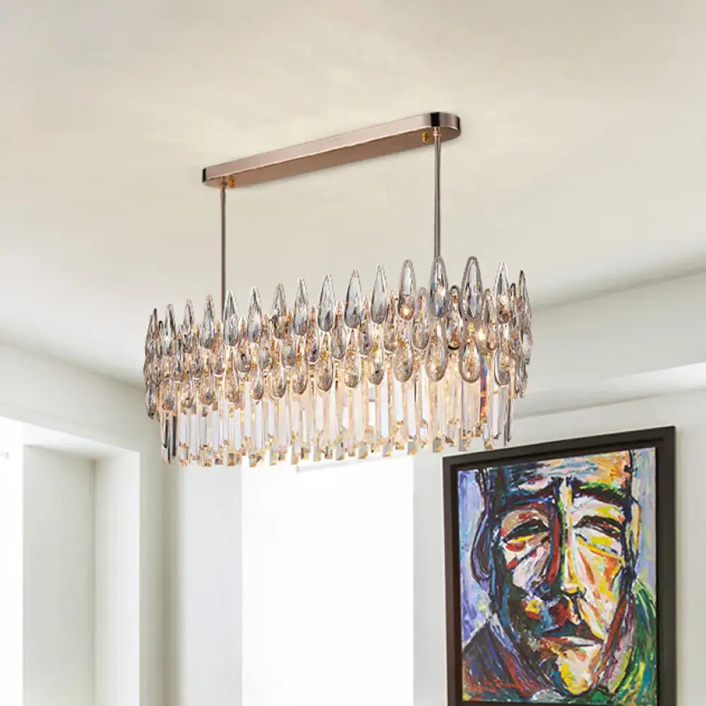 A modern rectangular chandelier with rose gold metal frame and crystal tiers for gold island lighting in kitchens
