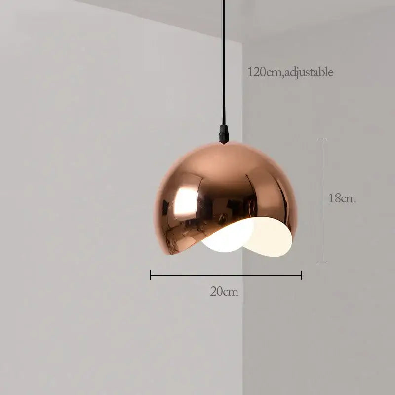 A sleek copper rose gold pendant light with a smooth reflective dome and adjustable black cord for dining decorbites decor