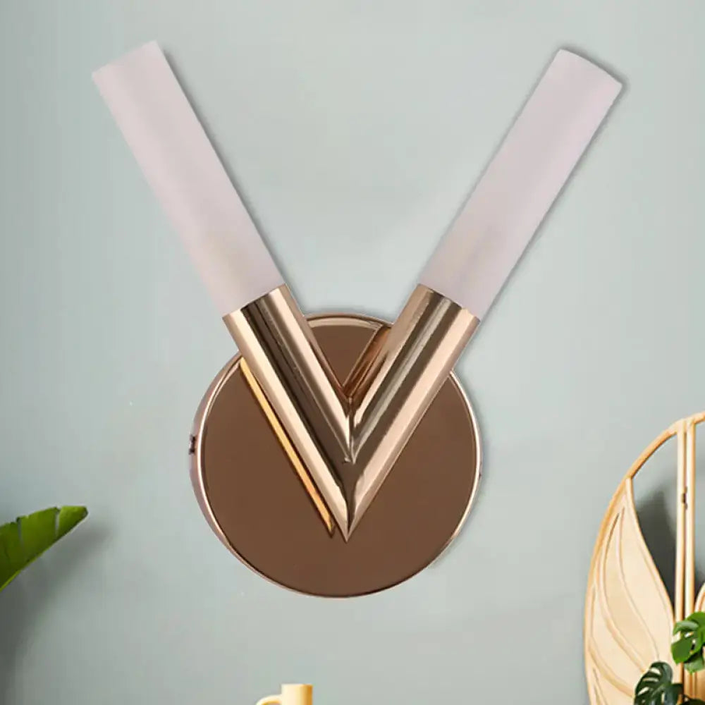 Modern v-shaped bedroom sconce with rose gold metallic finish and white glass shade for elegant lighting