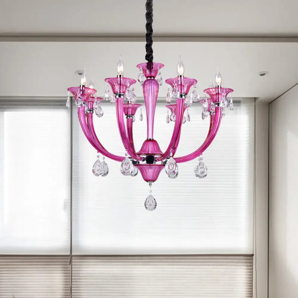 A vibrant rose red glass chandelier with crystal droplets and candle-style bulbs for living room decor