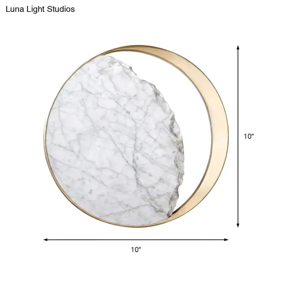 Modern round gold and white marble led wall sconce featuring a white marble slab with gray veining and a gold crescent frame