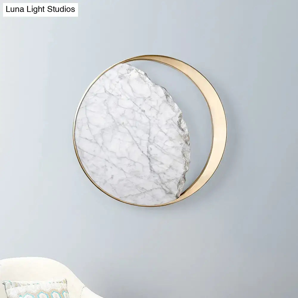 Modern round gold and white marble led wall sconce featuring a circular white marble slab with gray veining and gold frame