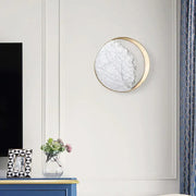 Modern round gold and white marble led wall sconce featuring a circular gold-toned frame and marble-like surface