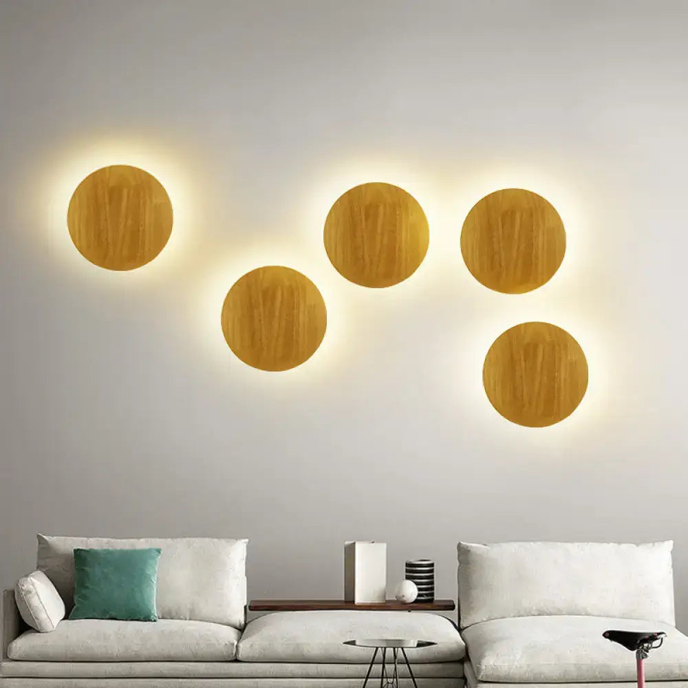 Five circular wooden led wall lighting fixtures with warm glowing light for modern living room use