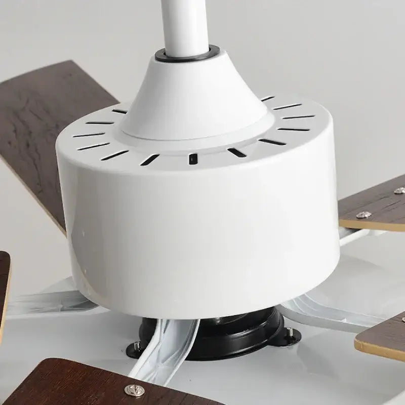 White ceiling fan motor housing with cylindrical design and black vents on modern sage green wooden led ceiling fan