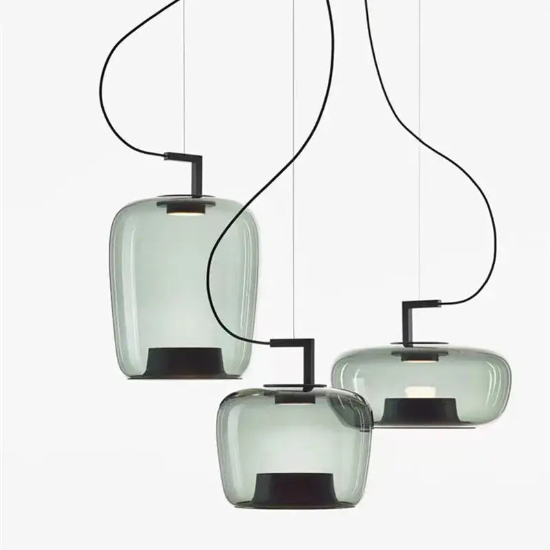 Three modern decorbites brokis glass pendant lamps with translucent sage green glass shades and black metal fixtures
