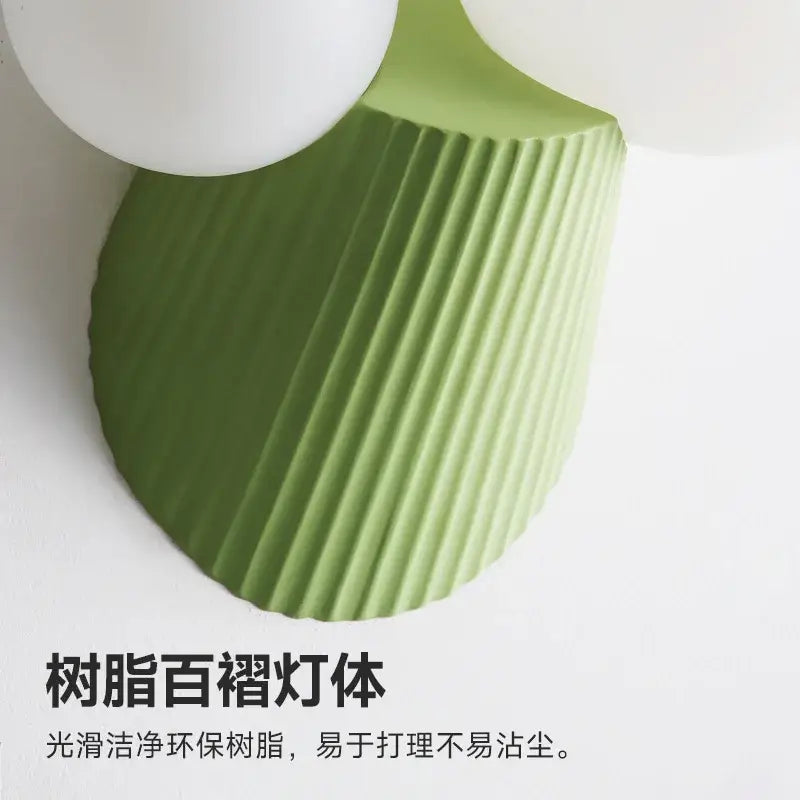 A sleek sage green decorbites cactus resin glass wall lamp with a ribbed eco-friendly resin base for bedrooms