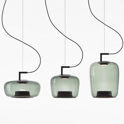 Three sleek translucent sage green glass pendant lamps with black metal fixtures ideal for dining room lighting