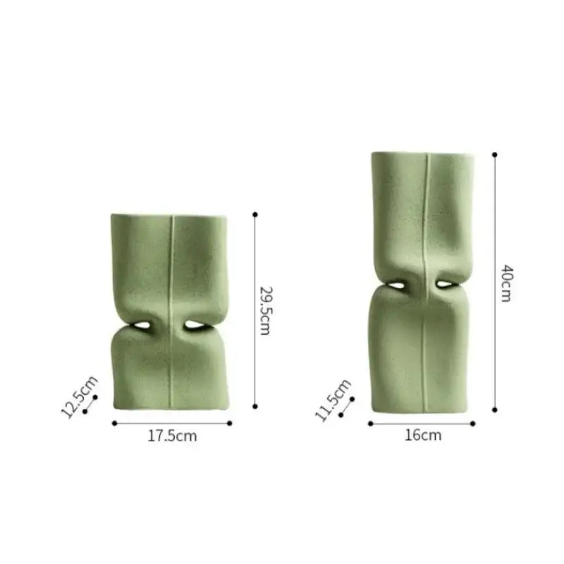 Two matte sage green hollow ceramic vases with modern abstract design for living room face decor