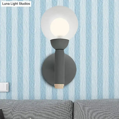 Modern sage green macaron style torch wall light with grey white frosted glass globe and wooden accent for bedroom sconce