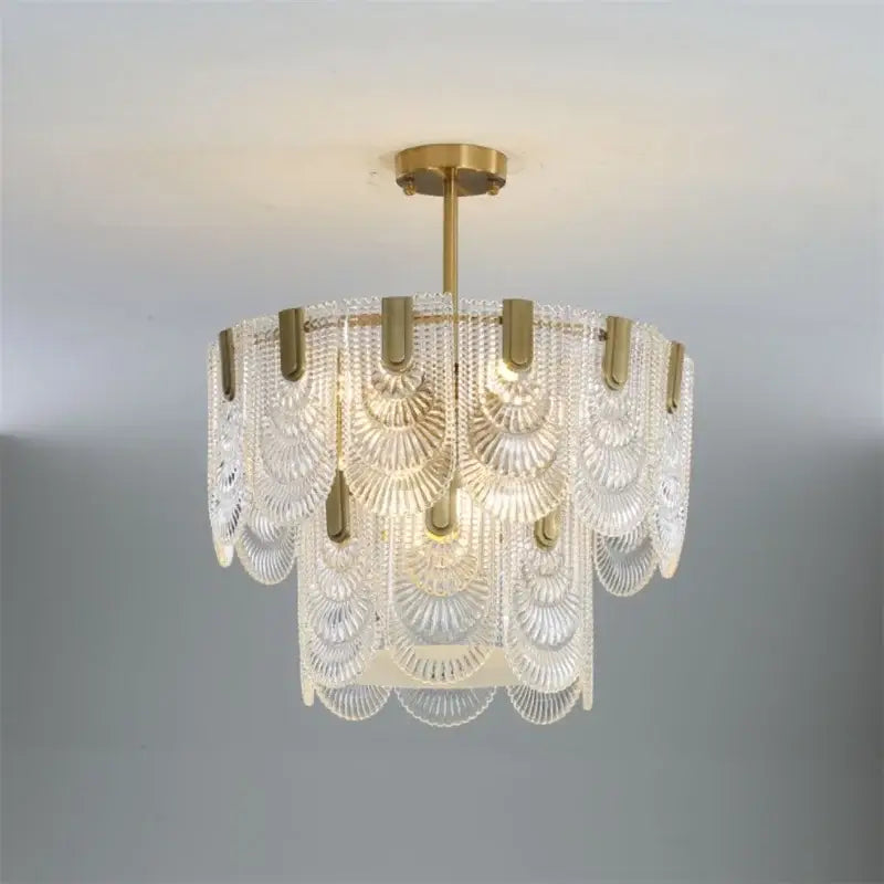 Elegant gold scalloped art glass chandelier featuring cascading clear glass fan-shaped panels for dining room decorbites art glass