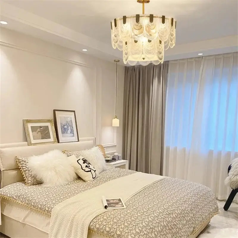 A tiered cream-colored decorbites art glass chandelier with gold-toned accents for modern dining room decor