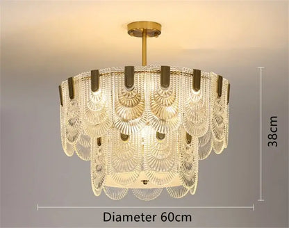 A modern scalloped gold dining room glass chandelier with a gold-toned metal frame and decorbites art glass tiers