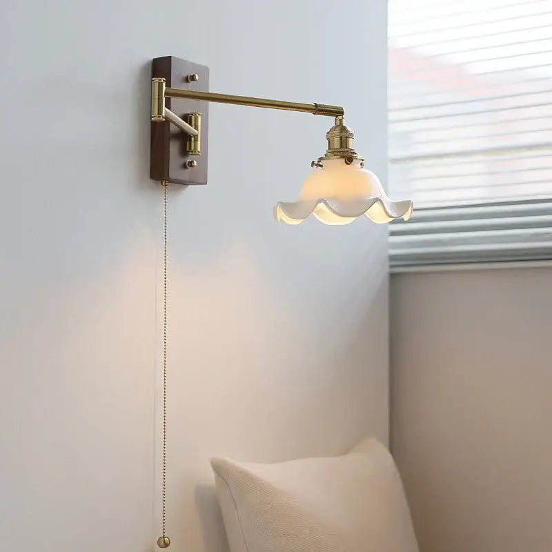 Brass wall light with a dark wood base and off-white scalloped glass shade, ideal for bedroom reading decorbites ceramic led
