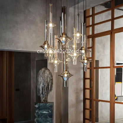 Modern sculptural glass pendant light with metallic accents and warm glowing bulbs for dining room use
