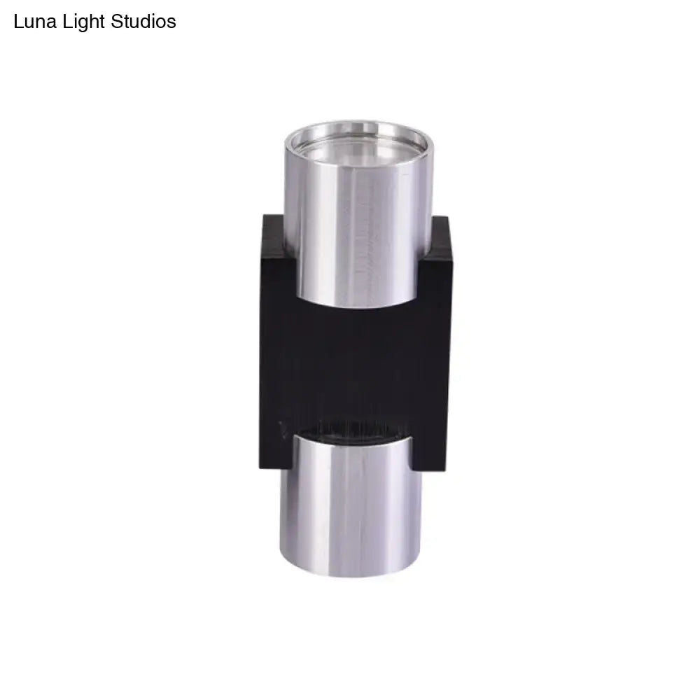 Modern silver aluminum led wall light fixture with a cylindrical design and black rectangular base for bedroom accent lighting