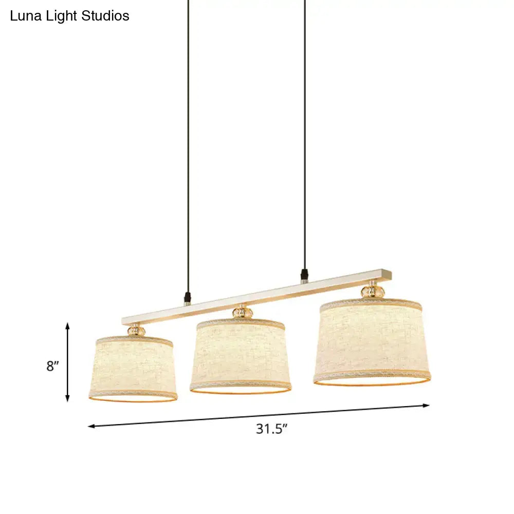 DecorBites modern three-light circle pendant light with white wood bar gold hardware and flaxen fabric shades for kitchen island