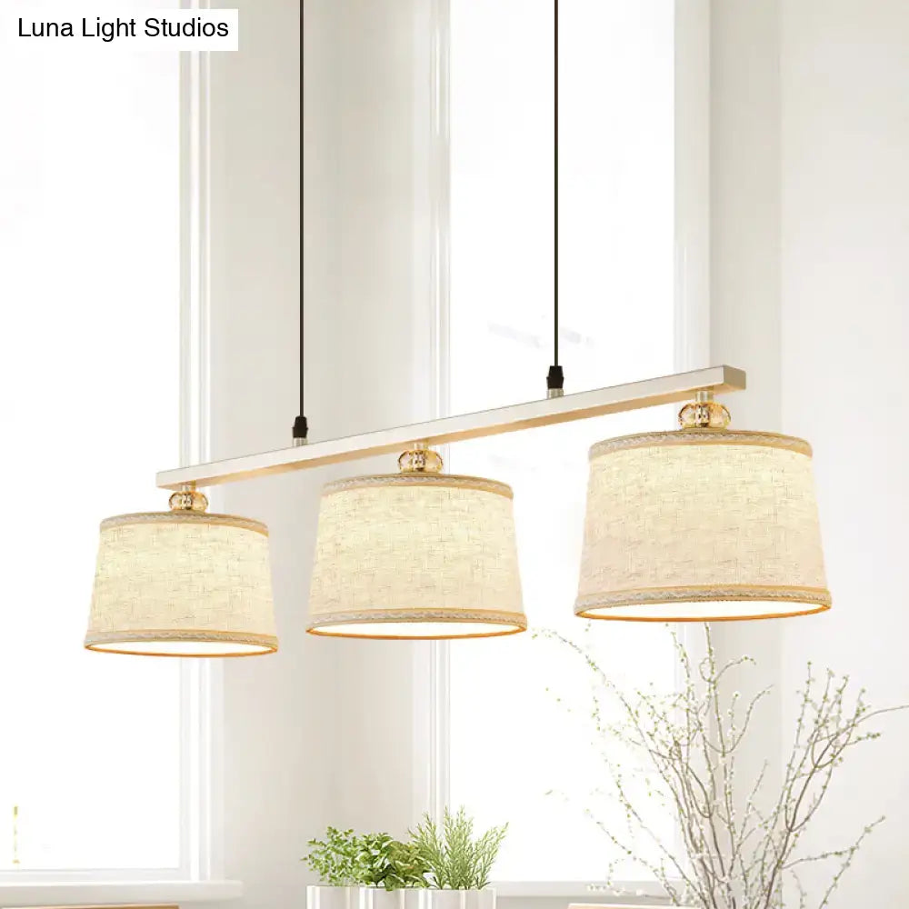 Modern circular pendant light with three beige linen shades gold hardware for kitchen island lighting by DecorBites