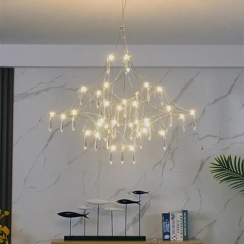 A modern silver and golden lustre crystal chandelier with a metallic frame and dangling droplets for living room decorbites golden lustre