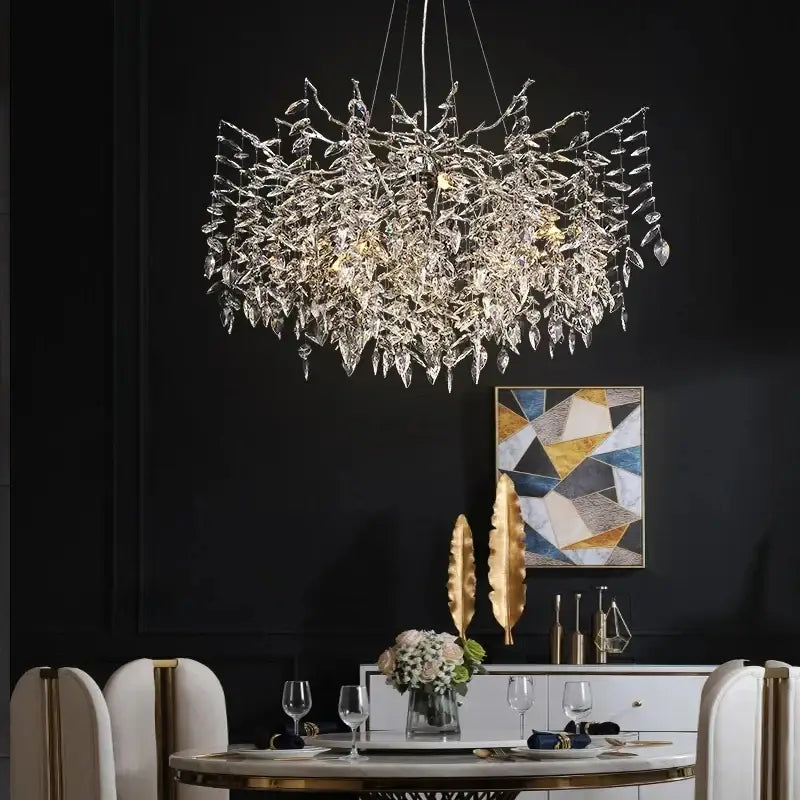 Modern silver and black crystal chrome chandelier with intricate leaf branches and teardrop crystals above dining table